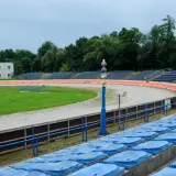 Puste trybuny stadionu Wandy Kraków z widokiem na tor żużlowy i boisko.