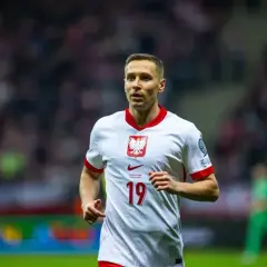 Piłkarz Przemysław Frankowski w białej koszulce z numerem 19, reprezentujący Polskę. Jego obecne drużyny to RC Lens i reprezentacja Polski.