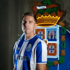 Piłkarz w koszulce FC Porto, gdzie gra Bednarek. Za nim neonowy herb klubu.