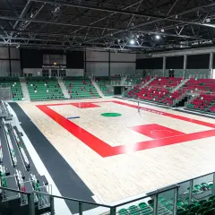 Pusta hala sportowa z parkietem do koszykówki i trybunami w Zagłębiowskim Parku Sportowym.