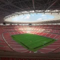 Nowy stadion w Budapeszcie z zieloną murawą i czerwonymi trybunami. Piłkarze trenują przed meczem.