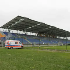 Pogoń Siedlce stadion z ambulansem na murawie. Puste trybuny czekają na kibiców.