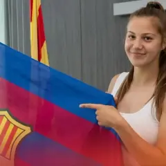 Uśmiechnięta Emilia Szymczak trzyma flagę FC Barcelony.