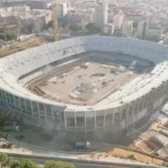 Widok z lotu ptaka na stadion barcelony nowy w budowie. Widać dźwigi i robotników pracujących nad konstrukcją.