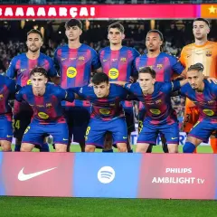 Drużyna FC Barcelona, w tym zawodnicy jak Lewandowski, Pedri i Gavi, pozuje do zdjęcia przed meczem.