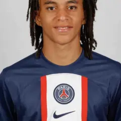 Młody piłkarz Ethan Mbappé w koszulce PSG. Jego wiek to 16 lat.