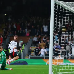 Emile Smith Rowe radośnie świętuje bramkę, podczas gdy bramkarz leży na murawie.