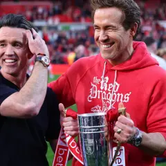 Ryan Reynolds i Rob McElhenney świętują sukces Wrexham A.F.C. z pucharem. Ich radość odzwierciedla pozytywne rankingi klubu.