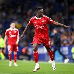 Piłkarz Sevilli w czerwonej koszulce wskazuje palcem, analizując statystyki meczu Getafe CF – Sevilla FC.