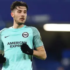 Piłkarz Jakub Moder w koszulce Brighton, zmagający się z kontuzją, na tle niebieskich trybun.