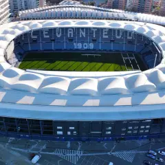 Estadi Ciutat de València, dom Levante U.D. z 1909, z zieloną murawą i białym, falistym dachem.
