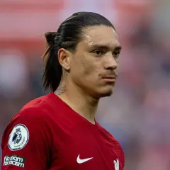 Darwin Nunez w czerwonej koszulce Liverpoolu, z charakterystycznym kucykiem i tatuażem na szyi, gotowy do gry.