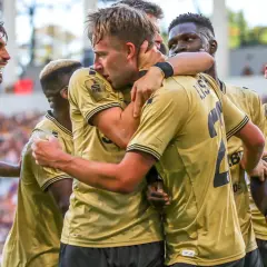 Radość zawodników Girona FC po zdobytej bramce. Piłkarze w złotych koszulkach świętują razem.