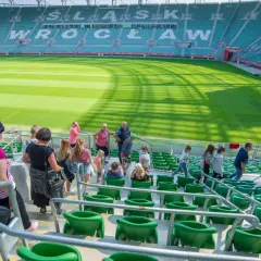 Grupa turystów zwiedza pusty stadion Śląsk Wrocław.