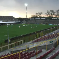 Stary stadion ŁKS, z murawą i trybunami, gdzie trwa mecz.
