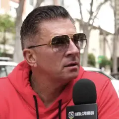 Mateusz Borek w czerwonej bluzie i okularach przeciwsłonecznych udziela wywiadu dla Kanału Sportowego, być może o Real Madryt.