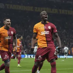 Dwóch zawodników Galatasaray świętuje zwycięstwo na boisku.