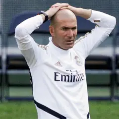 Zinedine Zidane, trener Real Madryt 2017, z rękami na głowie, w białej koszulce treningowej.