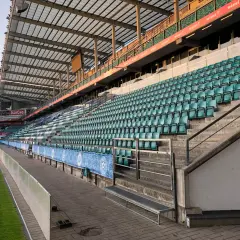 Puste trybuny stadionu A. Le Coq Arena czekają na kibiców. Zielone krzesełka tworzą morze nadziei na emocjonujące mecze.