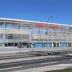 Nowoczesny stadion im. Kazimierza Górskiego w Płocku, z charakterystyczną, ażurową fasadą i niebieskimi bramami.