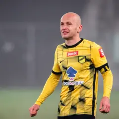 Piłkarz w żółtej koszulce z czarnymi pasami, gdzie gra Pazdan.
