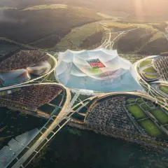 Futurystyczny kompleks sportowy z centralnym, zadaszonym stadionem, otoczony boiskami treningowymi i parkingami. Wygląda jak najwyżej położony stadion na świecie.