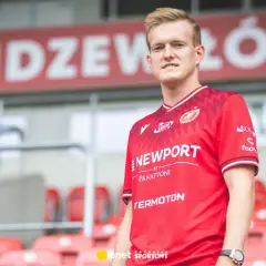 Piłkarz Karol Świderski w czerwonej koszulce Widzewa Łódź. Jego zarobki budzą zainteresowanie kibiców.