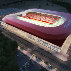 Nowoczesny stadion **El Sadar** w nocy, z czerwonym dachem i trybunami wypełnionymi kibicami. Obok budynek treningowy i parkingi.