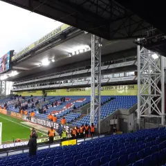 Puste trybuny stadionu Crystal Palace, z widokiem na murawę i tablicę wyników.