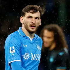 Piłkarz Napoli w niebieskiej koszulce, z logo Serie A na rękawie, w deszczu. Chwicza Kwaracchelia, daty dołączenia do klubu.