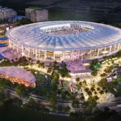 Nowoczesny **Inter Miami stadium** z rozsuwanym dachem, otoczony parkiem z boiskami i atrakcjami, nocą.
