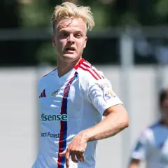 Jonatan Braut Brunes w białej koszulce z czerwonymi pasami, na boisku.