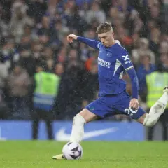 Cole Palmer w akcji, kopie piłkę podczas deszczowego meczu.