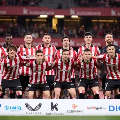 Athletic Bilbao – zawodnicy w czerwono-białych pasach stoją razem przed kibicami.