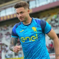 Piłkarz w błękitnej koszulce z żółtym logo "enel" i bykiem, widać trybuny stadionu. To moment, kiedy gra Linetty.