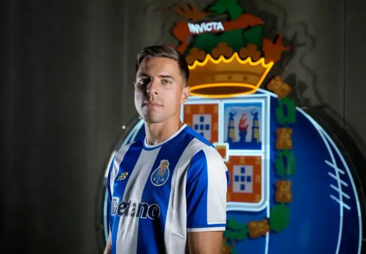 Piłkarz w koszulce FC Porto, gdzie gra Bednarek. Za nim neonowy herb klubu.