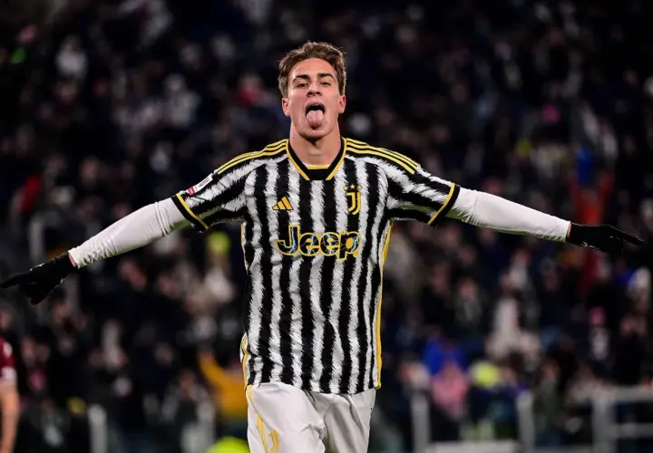 Kenan Yıldız w koszulce Juventusu z językiem na wierzchu, radośnie świętuje bramkę.