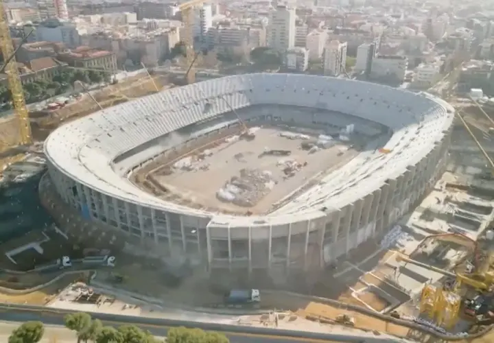 Widok z lotu ptaka na stadion barcelony nowy w budowie. Widać dźwigi i robotników pracujących nad konstrukcją.