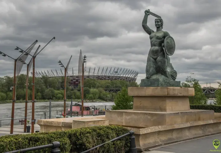 Syrenka Warszawska z tarczą i mieczem, w tle PGE Narodowy.