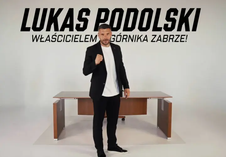 Łukasz Podolski, właściciel Górnika Zabrze, w garniturze przed biurkiem. Najnowsze wiadomości z klubu.