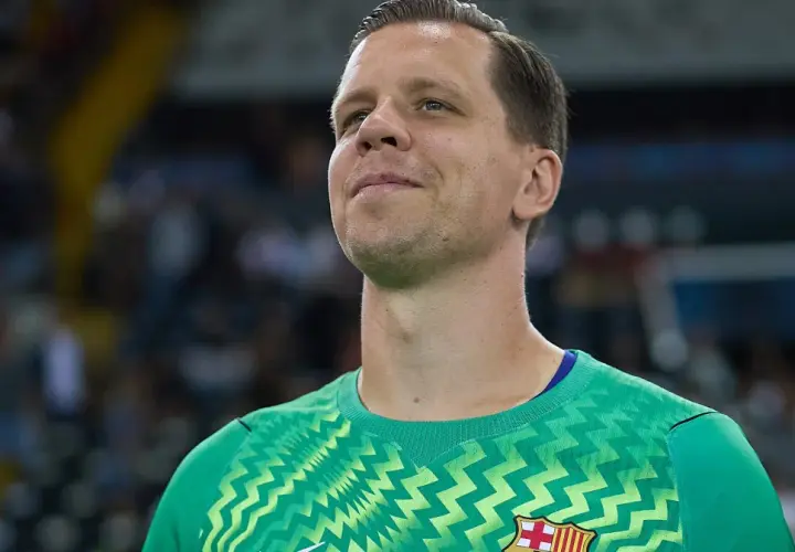 Wojciech Szczęsny w zielonej bramkarskiej koszulce, z uśmiechem na twarzy, gotowy do gry.