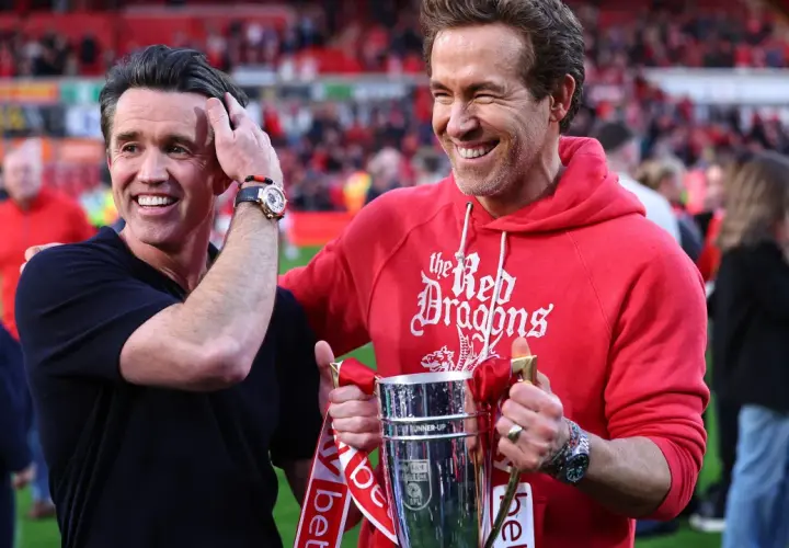 Ryan Reynolds i Rob McElhenney świętują sukces Wrexham A.F.C. z pucharem. Ich radość odzwierciedla pozytywne rankingi klubu.