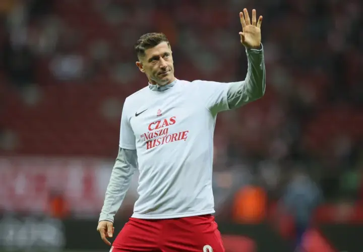 Zbigniew Robert Lewandowski w koszulce z napisem "Czas na naszą historię" pozdrawia kibiców.