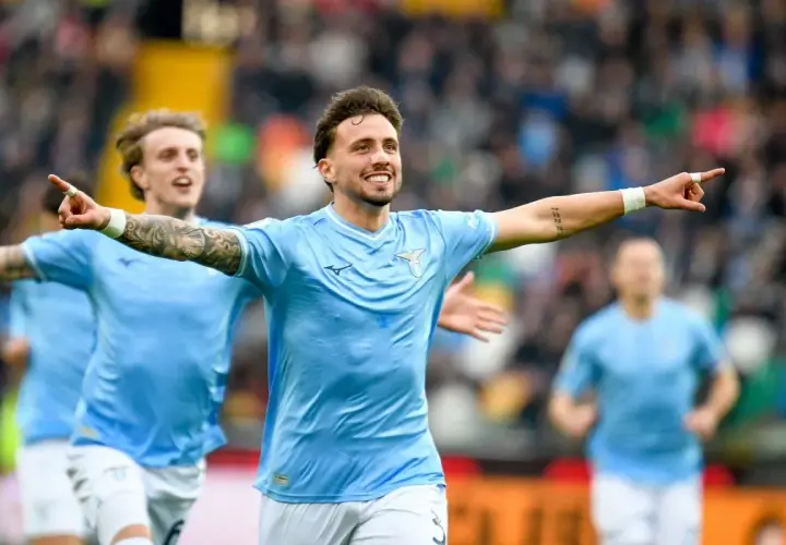 Piłkarz Lazio cieszy się z bramki przeciwko Udinese, z kolegami z drużyny w tle.