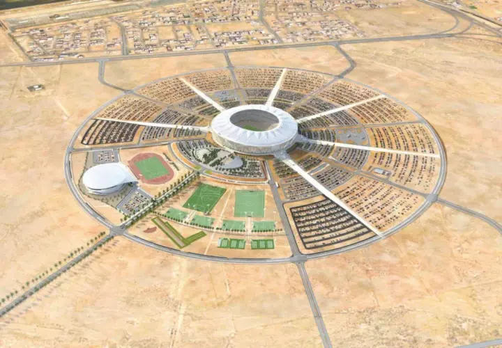 Okrągły kompleks sportowy z centralnym stadionem, otoczony parkingami i boiskami. To wizualizacja King Abdullah Sports City.