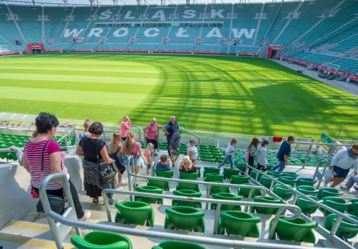 Grupa turystów zwiedza pusty stadion Śląsk Wrocław.
