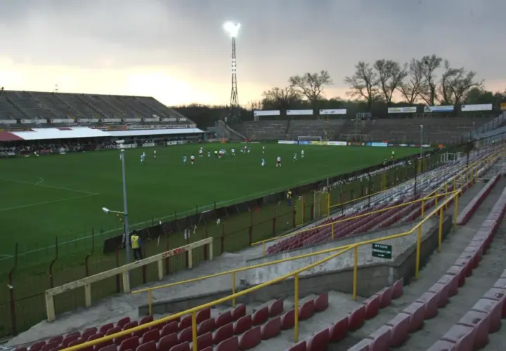 Stary stadion ŁKS, z murawą i trybunami, gdzie trwa mecz.