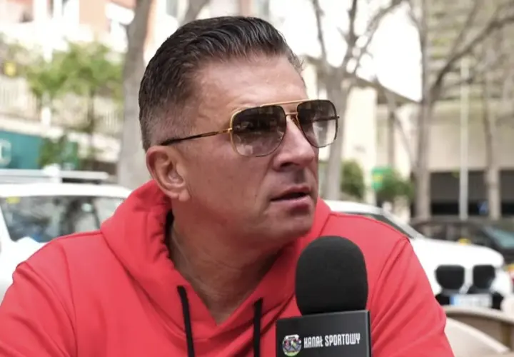 Mateusz Borek w czerwonej bluzie i okularach przeciwsłonecznych udziela wywiadu dla Kanału Sportowego, być może o Real Madryt.