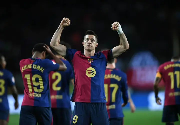Robert Lewandowski świętuje kolejne bramki, podnosząc ręce w geście triumfu.