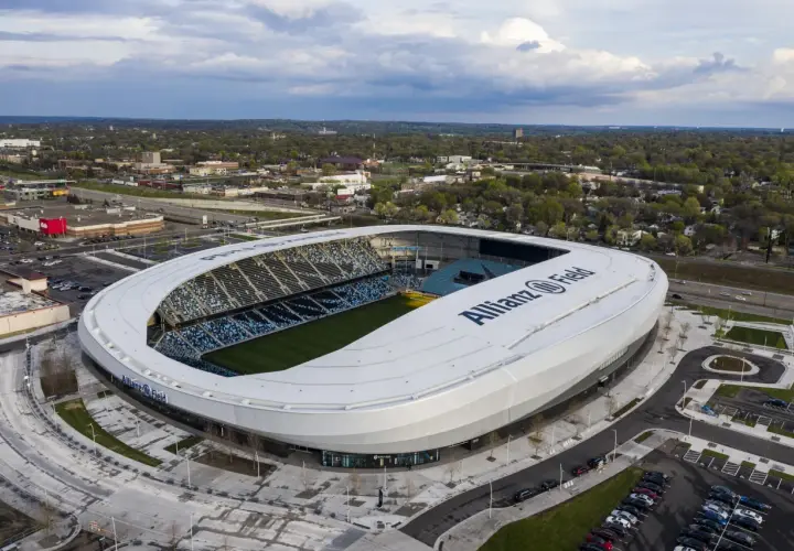 Widok z lotu ptaka na Allianz Field, nowoczesny stadion piłkarski, otoczony zielenią i parkingami.